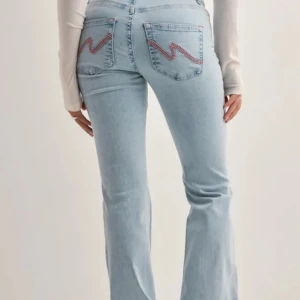 Ljusblå bootcut jeans med slitningar från Nelly - Säljer ett par ljusblå bootcut jeans med slitningar vid knäna och broderad detalj på bakfickorna. Jeansen har klassisk femficksdesign och stängs med dragkedja och knapp. Perfekta för en avslappnad och trendig look. säljer då jag ej använder de längre. Hör av er för egna bilder!😊 