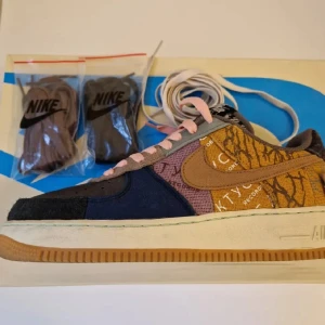Nike Air Force 1 Low Cactus Jack - Nike Air Force 1 Low Cactus Jack med unik patchwork-design i flera färger som blå, svart, brun och gult. Skon har snörning, gummisula och tydliga detaljer med olika mönster och material. Kommer med extra skosnören. Skicket är 9/10, både box och original snören följer med.