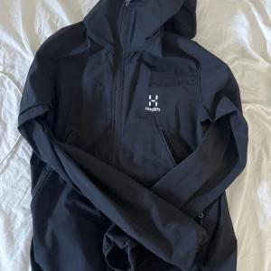 Svart vindjacka från Haglöfs - Tja! Säljer denna Haglöfs jacka i storlek S. Skicket är användsbart, kan finnas en del defekter då den är väldigt använd, dock inget som direkt syns. Jag är 179 cm och väger 65 kg och sitter perfekt. Tveka inte att höra av dig om du har frågor eller vill ha fler bilder!