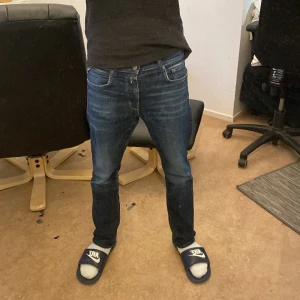 Blå jeansbyxor från Replay - Säljer ett par klassiska blå jeansbyxor från Replay, Jeansen har normal passform och snygga kontrastsömmar. Perfekta för dig som gillar en tidlös stil och vill ha ett par jeans som funkar till det mesta. Rekommenderar att vara runt 165-180 beror på hur man vill att de ska sitta, borde sitta perfekt om man är runt 170