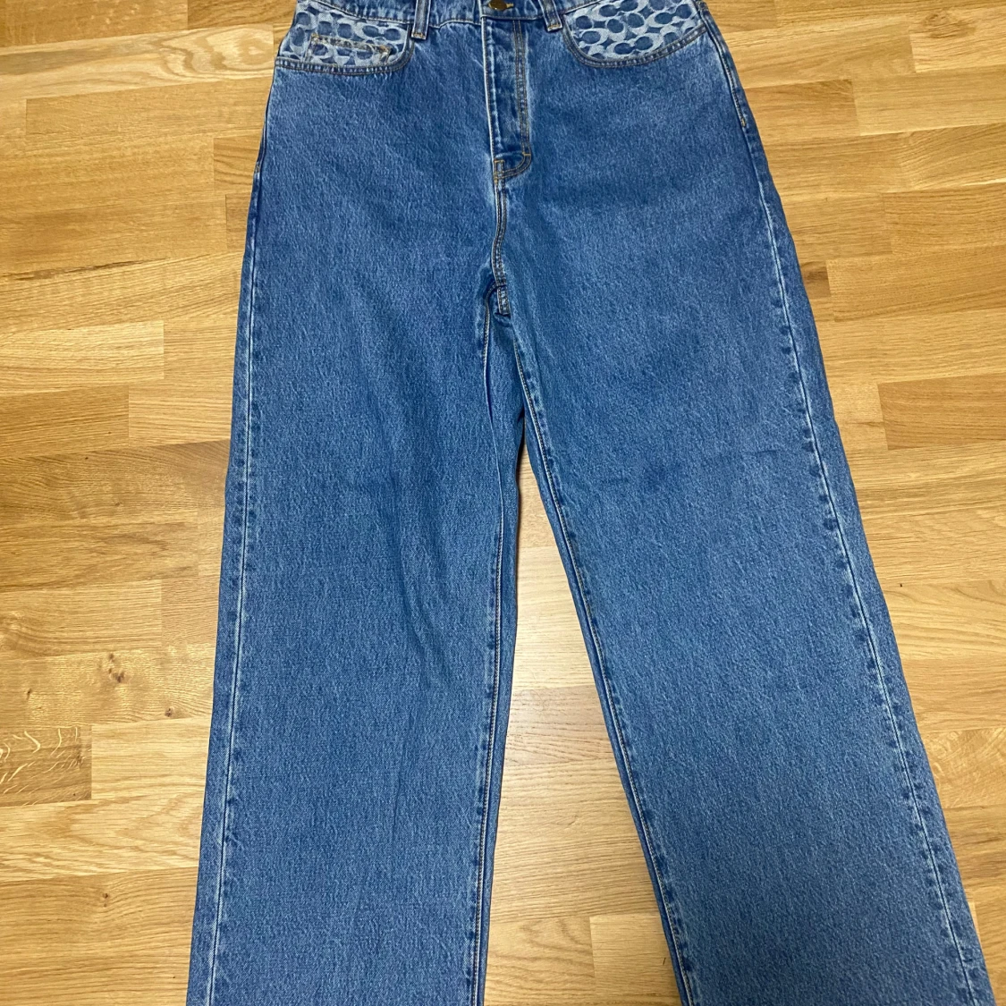 Blå jeansbyxor från Coach med mönstrade fickor