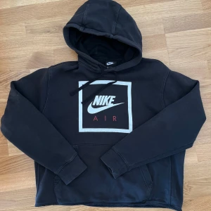 Nike hoodie  - Vintage Nike hoodie i använt men bra skick! Jag har klippt av mudden längst ner för en mer ”hängande”/kort passform, jag har dock behållt sömmen så inget som påverkar kvaliteten! Den är lite urtvättad och lite sprucket tryck men annars i fint skick :)
