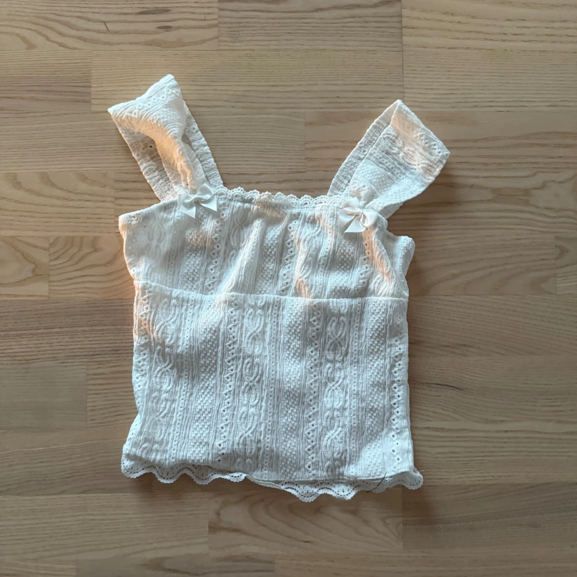 Vit spetslinne med rosett