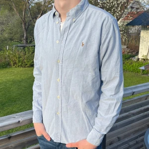 Ljus blå Ralph lauren skjorta - Säljer väldigt fin Ralph lauren skjorta i perfekt skick, inga tecken på användning, snygg färg och perfekt inför sommaren, frakstas inom 48h och bara att skriva vid funderingar
