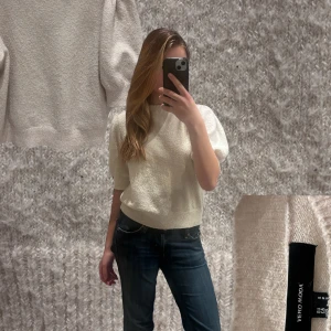 Beige kortärmad stickad topp med puffärm från Vero Moda - Säljer en söt ljusbeige stickad topp från Vero Moda med korta puffärmar och ribbade muddar. Perfekt nu inför sommaren. Använd väldigt få gånger, säljer då den inte kommer till användning. 