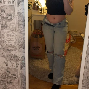 Ljusblå jeansbyxor från Gina Tricot - Säljer ett par ljusblå jeansbyxor från Gina Tricot med raka ben och slitna detaljer vid knäna. Byxorna har klassisk femficksdesign och normal passform. Säljes tyvärr då dem är för små för mig.