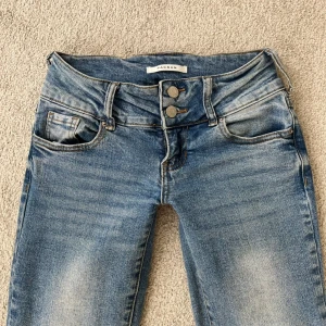 Blå lågmidjade jeans från Pacsun🌟 - Säljer dessa blåa, lågmidjade bootcut jeans från Pacsun. De har en liten slit på utsidan av varje ben. Midjemått: 33cm, midjehöjd: 17cm, lårmåttet: 21,5cm, Innerbenslängd: ca 79cm. Säljer då dem är lite försmå för mig. Köpta i USA. Hör av dig vid frågor🩷