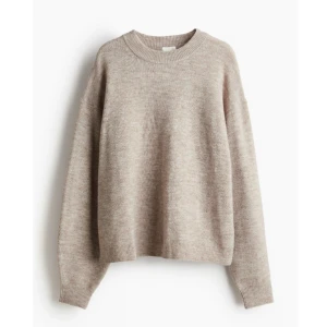 Beige stickad tröja - Beige stickad tröja med rund halsringning och långa ärmar. Tröjan har en avslappnad passform och ribbade muddar vid ärmslut och nederkant.