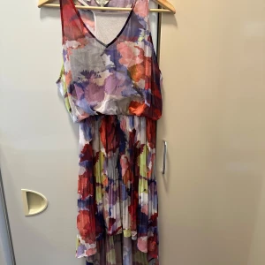 Färgglad blommig långklänning från Guess - Säljer en långklänning från Guess i storlek M. Klänningen är ärmlös med v-ringning och har ett färgstarkt blommigt mönster i lila, rött, blått och vitt. Materialet är lätt och luftigt, perfekt för sommarens tillfällen speciellt nu till alla student firanden. Klänningen har lite defekter som men kan se på andra bilden och att ena bandet till under klänningen är lös från klänningen som man kan se på bild nr 3!🩷