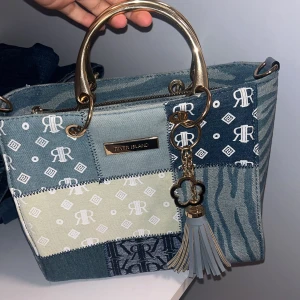 Väska  - Säljer en snygg axelväska från River Island i patchwork-stil med olika blå och beige denimtyger. Den har bara använts en gång! Kontakta för mer information 🫶 pris går att diskutera 