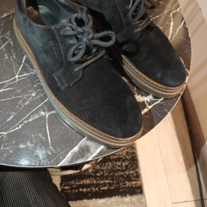 Gant skor nästan nya använt endast 1 gång 43 storlek - Snygga svarta skor i mocka med rund tå och platt sula. Skorna har klassisk snörning och en diskret brun rand längs sulan. Perfekta för en stilren och enkel look.