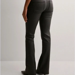 Svarta bootcut, low waist skinnbyxor - Den populära och slutsålda Nelly byxorna. Snygga svarta byxor med bootcut passform och låg midja . Byxorna har klassiska fickor och är gjorda i skinnimitation som ger en cool look. Perfekta att styla med klackar eller sneakers.Storlek 38