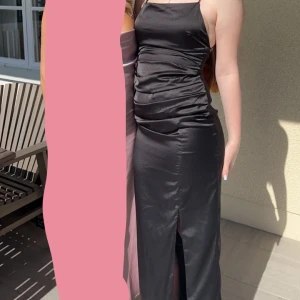 Svart satin klänning - Säljer min suck klänning då den inte kommer användas igen. Den är super fin med slits i benet och fin knytning i ryggen. Visar mer om du är intresserad🩷