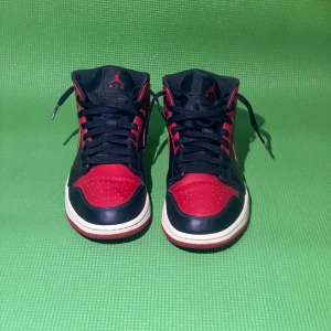 Nike Air Jordans svart/röd - Säljer ett par klassiska Nike Air Jordans i svart och rött med vita sulor. Skorna har snörning, rund tå och den ikoniska swoosh-loggan på sidan. Perfekta för dig som gillar streetwear och vill sticka ut med en tidlös sneaker. Pris kan diskuteras kom gärna med förslag. 