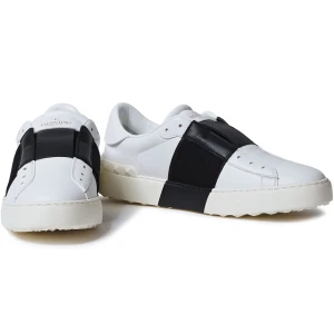 Valentino Open sneakers i vitt och svart - Säljer ett par snygga Valentino Open sneakers i vitt skinn med bred svart rem över mitten. Skorna har en chunky vit sula med nitar baktill och rund tå. Perfekta för dig som gillar stilrena och exklusiva sneakers.