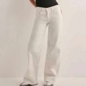 Vita wide leg jeans - (Aldrig använda med lapp kvar!!!) Säljer dessa vita jeans med wide leg och låg midja från Nelly som är så trendiga nu till sommaren! Byxorna har klassisk femficksdesign, bälteshällor och stängs med knapp och dragkedja. Perfekta för en clean och trendig look. Slutsålda på hemsidan💕💕