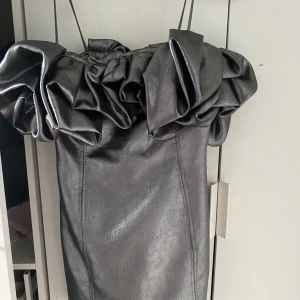 Silver/grå klänning med volang från Zara - Silver grå klänning från zara, har bara användt den en gång. Kom privat för bättre bilder och pris kan diskuteras. Den är kort och sitter mer figurnära än vad den gör på bilden 