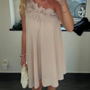 Beige klänning med volang - Säljer en söt beige klänning med volangdetaljer runt halsen. 💖