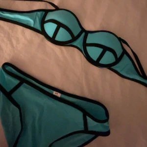 Turkos bikini med svarta kanter - Säljer en turkos bikini med svarta kontrastkanter. Bikinin har bygel-bh med vadderade kupor och matchande trosor. Snygg och modern design, perfekt för stranden eller poolen. Helt ny då den inte passa.