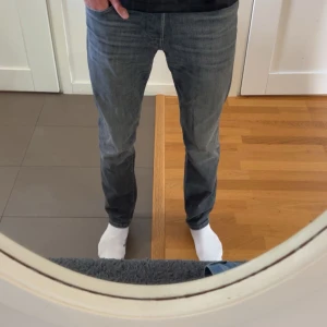 Grå jeans från Jack & Jones - Säljer ett par grå jeans från Jack & Jones.  Jeansen är slim fit och är nästan helt oanvända, har använt de säkert 10 gånger max! Nypris 999kr från jack&jones hemsida och säljer pga av att de blivit lite tajta i midjan. Priset går att diskutera vid snabb affär
