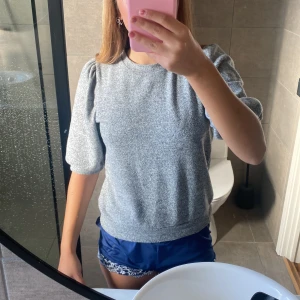 Grå puffärm tröja från Lager 157 - Säljer en grå tröja från Lager 157 i storlek S med puffärmar och rund hals. Tröjan har en mjuk och skön känsla, perfekt för chill dagar. Materialet är bomull och polyester.