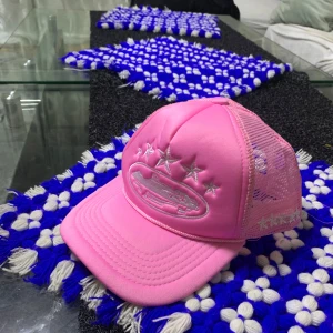 Corteiz keps - Säljer en snygg rosa keps med mesh på sidorna och bak, samt broderade stjärnor och ett motiv framtill. Kepsen har böjd skärm och justerbar passform. Perfekt för dig som vill sticka ut med en färgglad och cool accessoar.