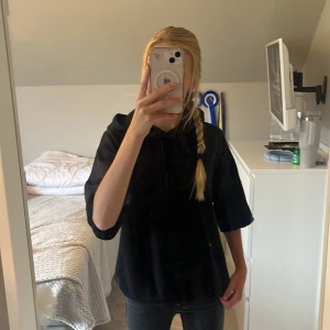 Svart hoodie från H&M med snörning - Svart hoodie från H&M med huva och snörning framtill.  Tillverkad i mjuk bomull som är skön mot huden. Pris kan diskuteras