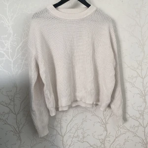 Vit stickad tröja från 157 - Säljer en vit stickad tröja från 157 i storlek M. Tröjan har en rundad halsringning och ribbade muddar vid ärmslut och nederkant. Den är loose fit och har långärmade ärmar, perfekt för att hålla dig varm under kyliga dagar.