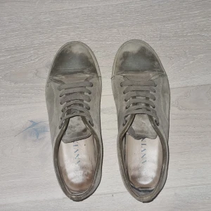 Bruna lanvins - Snygga sneakers från Lanvin i grå mocka med rund tå och platt sula. Skorna har klassisk snörning och en stilren design som passar till det mesta. Perfekta för dig som gillar en clean och avslappnad look. Passar även 43