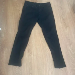 Svarta Levi's 511 jeans W34 L32 - Svarta Levi's 511 jeans med slim passform och klassisk femficksdesign. Jeansen har en snygg rak siluett och är tillverkade i slitstarkt bomullsmaterial med lite stretch för extra komfort. Perfekt för dig som gillar en stilren och modern look.