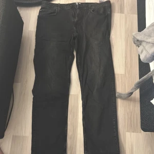 Svarta jeans från Only & Sons W38 L32 - Svarta jeans från Only & Sons med regular fit och klassisk femficksdesign. Jeansen har rak passform och är tillverkade i slitstarkt bomullsmaterial med en snygg mörk tvätt. Perfekta för dig som gillar en enkel och stilren look.