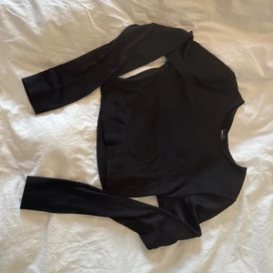 Svart ribbad croppad tröja Gina Tricot - Säljer en svart croppad långärmad tröja från Gina Tricot. Tröjan är ribbad och har en rund halsringning. Perfekt att styla med höga jeans eller kjol. Materialet är mjukt och stretchigt, vilket gör den bekväm att bära hela dagen.