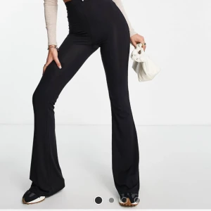 Svarta yogapants  - Säljer ett par svarta yogapants från ASOS tall med hög midja och stretchigt material. Byxorna har en slim passform upptill och vida ben nedtill. Väligt långa och aldrig använt