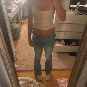 Ljusblå bootcut jeans från True Religion - Säljer ett par ljusblå jeans från True Religion med klassisk logga på bakfickan och snygga detaljer på fickorna. Modellen är bootcut med låg midja och har en faded tvätt som ger en chill vibe. Jeansen är i jeansmaterial och har knappar och dragkedja framtill. Köpt för 1300 säljer för 1100kr. Knappt andvänt dom. Färgen på jeansen finns inte längre o köpa