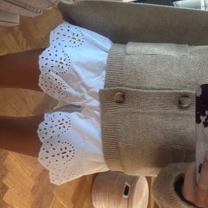 Vita broderade shorts med spetskant - Superfina vita shorts med breda ben och broderad spetskant. De har en luftig passform och är tillverkade i bomull, vilket gör dem perfekta för varma dagar. Spetsdetaljerna ger en söt och fräsch vibe, och midjan är normal. Perfekt till sommarens alla häng!