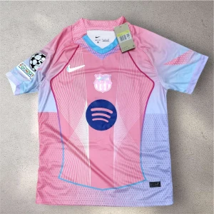 Barça Lamine Yamal rosa matchtröja Nike - Säljer en Barcelona fotbollströja med Lamine Yamal och nummer 19. Tröjan är rosa med ljusblå detaljer, vita linjer och mörkblå tryck. Kortärmad med klubbmärke, Champions League-patch och Spotify-logga. Materialet är lätt polyester, perfekt för träning eller match.