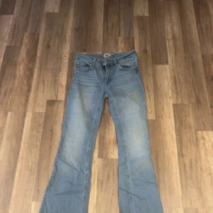 Bootcut ljusblå jeans från 157, S - Säljer ett par ljusblå bootcut jeans från 157 i storlek S med kort benlängd. Klassisk femficksmodell med dragkedja och knapp framtill. Jeansen har en snygg tvätt och är gjorda i mjukt denimtyg som sitter skönt. Perfekt för dig som gillar retrovibbar och bootcut.
