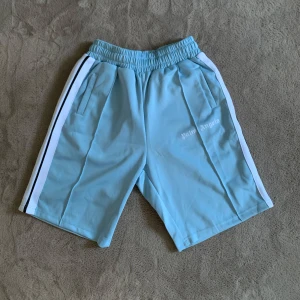 Ljusblå Palm Angels Shorts - Säljer ett par riktigt snygga baby blue Palm Angels shorts i storlek S. De är helt nya och oanvända, Vid fler frågor eller funderingar skicka ett pm, Mvh