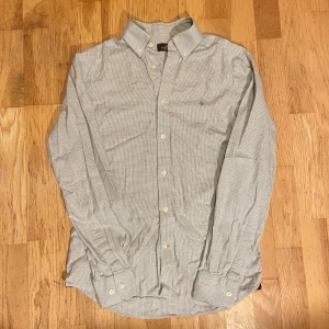 Helt ny Grå skjorta - Morris - Säljer en helt ny grå skjorta från Morris i storlek S. Den är grå/vit rutig och har Morris loggan på bröstet. Skicka ett DM vid frågor! FRAKTAR INOM 24H