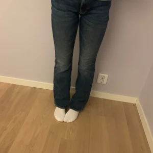 Blå bootcut jeans från Lindex - Blå jeans i bra skick från Lindex med low waist bootcut-passform. Står på lappen strl 40, men passar inte mig längre eftersom de har krympt i tvätten, så numera en storlek 38.
