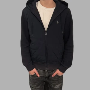 cardigan från Polo Ralph Lauren - Säljer en snygg cardigan från Polo Ralph Lauren med dragkedja och broderad logga på bröstet. Nypris 3000