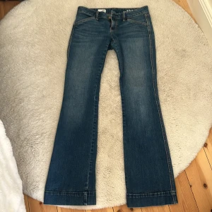 Ett par low waist bootcut jeans från gap! - Jätte fina blåa low bootcut jeans med knappar på fickorna där bak! De är i jätte bra skick,
