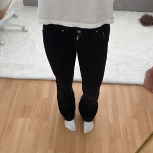 Svarta bootcut jeans från ginatricot - Säljer ett par svarta gina jeans med bootcut passform och mid waste. Klassisk femficksmodell med knapp och dragkedja framtill. Jeansen har en snygg, smal siluett upptill, vida nertill.