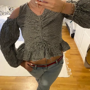 Svartvit rutig blus - Supersöt blus i svartvitt rutigt mönster med offshoulder och långa puffärmar. Storleken står inte men jag brukar ha S, skulle säga att den är S-M