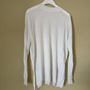 Vit polotröja från Monki - Säljer en vit polotröja från Monki i storlek S. Tröjan har en enkel och clean design med ribbad krage och långa ärmar. Perfekt för lager-på-lager och passar till allt. Materialet är mjukt och känns skönt mot huden.