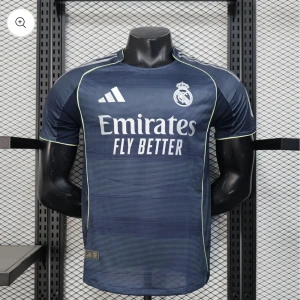 Marinblå Real Madrid fotbollströja - Snygg marinblå Real Madrid fotbollströja från Adidas med vita detaljer och tunna ljusgröna linjer längs axlar och ärmslut. Tröjan har korta ärmar, rund hals och är tillverkad i lätt, ventilerande material. Perfekt för match eller träning.