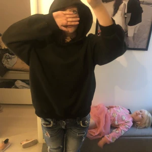 Svart oversize hoodie - Cool svart hoodie med stor vit statement-text på ryggen: 'Be the energy you want to attract'. Tröjan har huva och en loose passform, perfekt för dig som gillar streetstyle och vill sticka ut. Ungen i bakgrunden medkommer tyvärr inte. Lågtpris eftersom den e troligtvis gjord i barnarbete