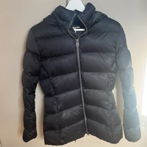 Svart dunjacka från Colmar med huva - Svart dunjacka från Colmar med huva och snyggt quiltad design.