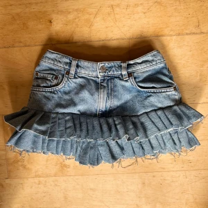 Ruffle jeanskjol - Supersöt kort jeanskjol i ljusblå denim med fransig volangkant längst ner. Sytt om den från ett par jeans. 