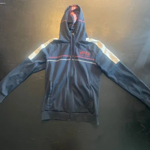 Hugo boss hoodie  - Nyrpis 2000kr Hugo boss hoodie i sportigt stuk. En nyare modell. En av de skönaste tröjorna jag har haft på mig dessutom är den väldigt snygg, alla mönster gör att man får en fin kropps siluett. väldigt liten repa på vänstra armbåge. Köpt i butik. 